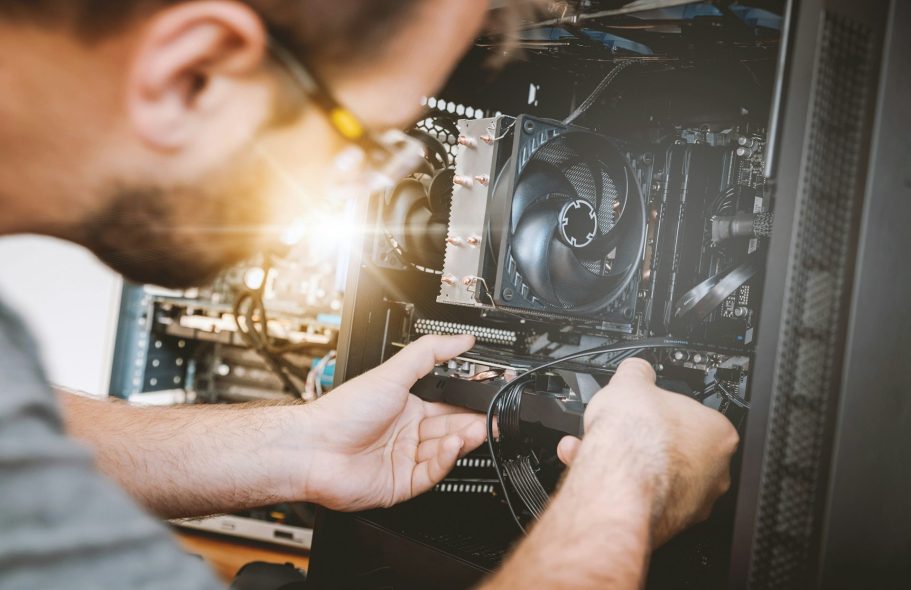 Person montiert Komponenten in einem Computergehäuse mit hellem Licht.